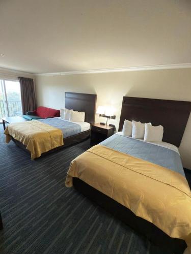 a hotel room with two beds and a window at Coratel Inn Ocean Shores Extended Stay in Ocean Shores