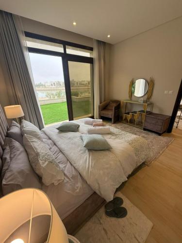 a bedroom with a large bed with a large window at Ocean Breeze Hawana in Salalah