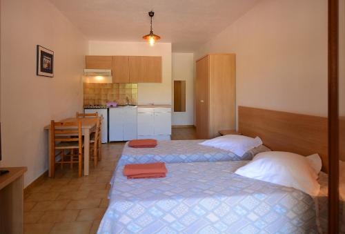 ポルティシオにあるMotel de Porticcioのベッドルーム1室(ベッド2台付)、キッチン(テーブル付)
