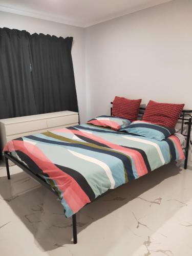 a bedroom with a bed with a striped comforter at Gaia's House self contained unit in Brisbane