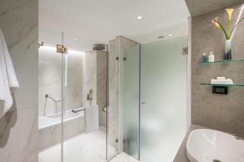 a bathroom with a shower and a toilet and a sink at The Inbal Jerusalem in Jerusalem