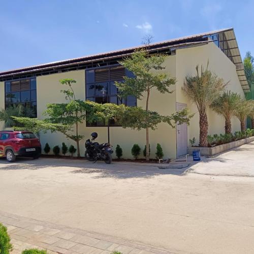 a motorcycle parked in a parking lot in front of a building at Hasiru Bhoomi Resort 