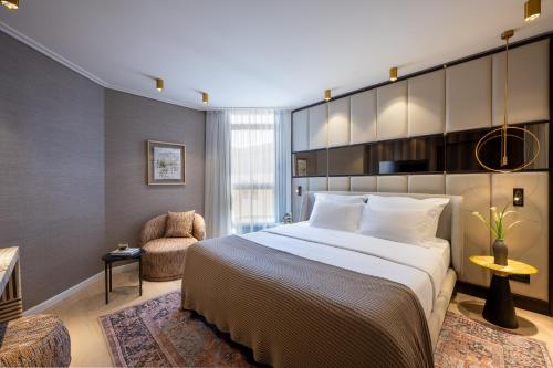 a hotel room with a large bed and a chair at The Inbal Jerusalem in Jerusalem