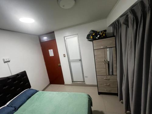 a small bedroom with a bed and a dresser at Huamanga plaza in Ayacucho