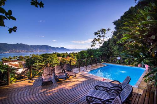 a deck with lounge chairs and a swimming pool at Pousada Perequê in Ilhabela