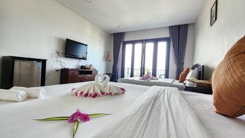 a hotel room with a bed with a flower on it at ZEN Resort - Villa beach- Garden in Xóm Tram
