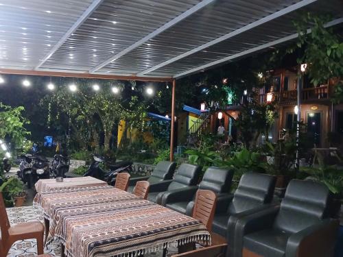 a patio with a table and leather chairs and a table and chairsktop at Catba Papillon Garden Bungalows & Resort in Cat Ba