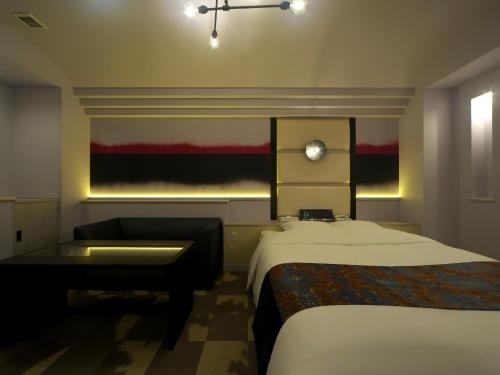 a hotel room with two beds and a desk and a window at HOTEL BOTA 豊橋 -Adult Only- in Toyohashi