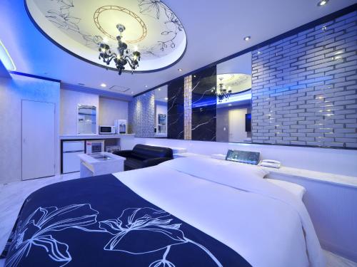 a bedroom with a large bed and a living room at HOTEL BOTA 豊橋 -Adult Only- in Toyohashi