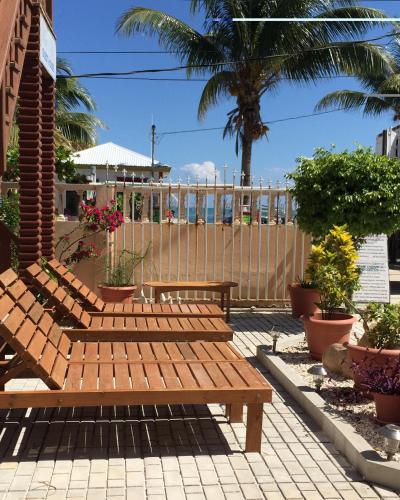 a group of wooden benches sitting on a patio at Blue Wave Guest House in Caye Caulker