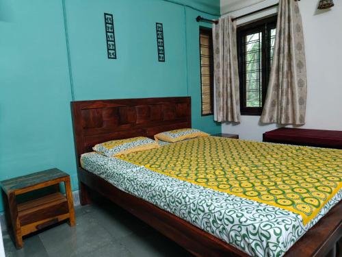a bedroom with a bed and a blue wall at Nivaant @ Vicharays in Alibaug