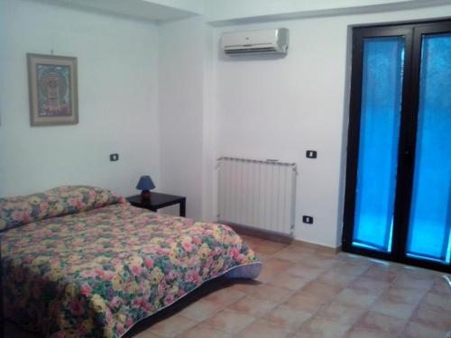 a bedroom with a bed and a window at Villa Oasi in Gaeta