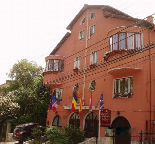 a building with flags on the side of it at Villa-Hotel Escala in Cluj-Napoca