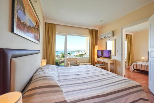 a hotel room with a large bed and a window at Nautica Bay Hotel in Porto Heli