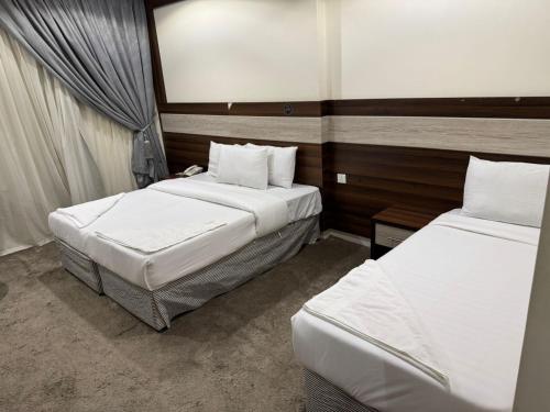 two beds in a small room with two beds sidx sidx sidx at فندق شعاع النزهة in Az Zāhir