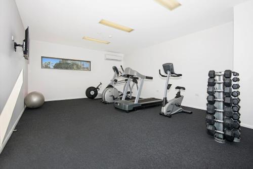 a gym with cardio equipment in a room at Marina View Apartment in Townsville