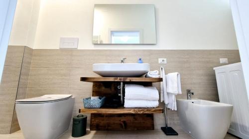 a bathroom with a sink and a toilet and a mirror at Piazza Vecchia Boutique Apartment in Bergamo
