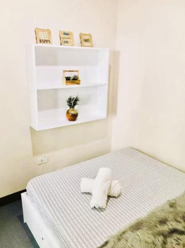a white room with a bed with a towel on it at Close by landmarks and airport in Manila