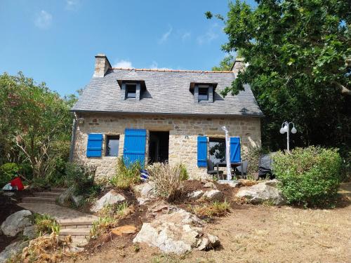 RoscanvelにあるMaison de pêcheur vue merの青いシャッター付きの古い石造りの家