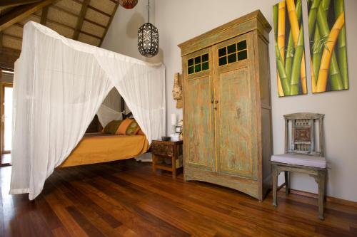a bedroom with a canopy bed and a wooden floor at 100% Fun in Tarifa
