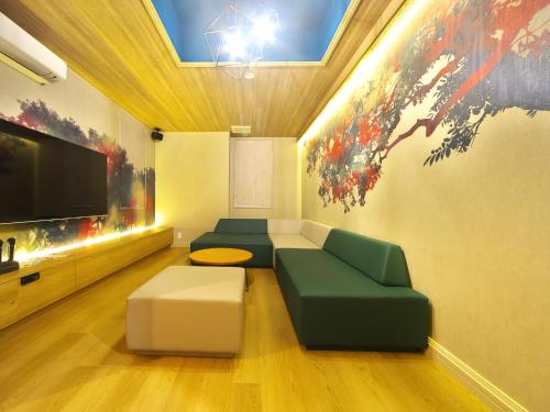 a living room with a couch and a flat screen tv at HOTEL BOTA 豊橋 -Adult Only- in Toyohashi