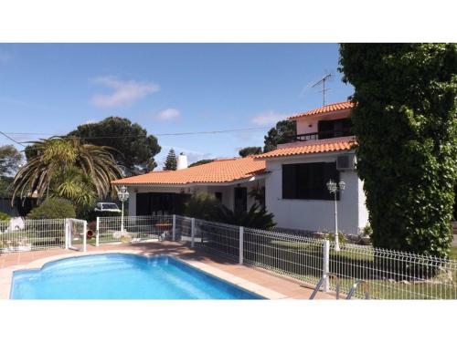 a house with a swimming pool in front of it at Casa Teresinha in Sesimbra