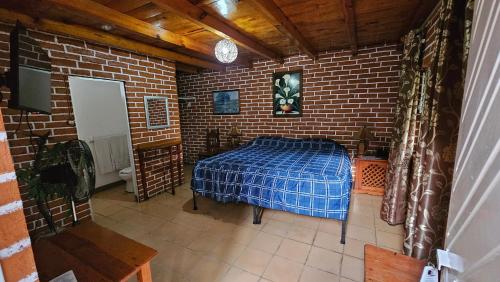 a bedroom with a bed in a brick wall at Hotel y Cabañas Manolo in El Pedregal