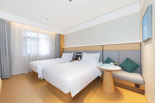 a hotel room with two beds and a table at Ji Hotel Beijing qianmeng dian 全季北京前门地铁站酒店 in Beijing