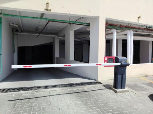 an empty parking lot with a parking meter in front of a building at Flatjuri in Muscat