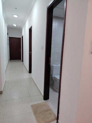 a hallway with a mirror and a toilet at Flatjuri in Muscat