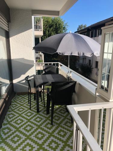 a table and chairs on a balcony with an umbrella at Pti Vélo in Annecy