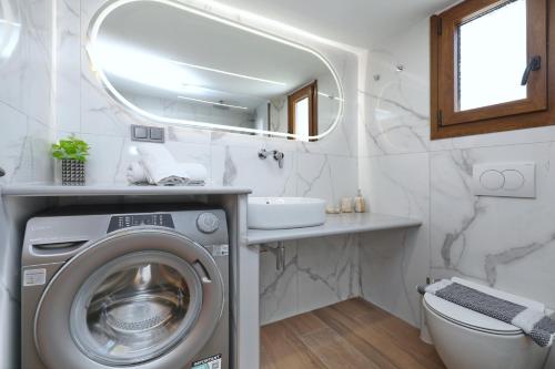 a bathroom with a washing machine and a sink at Smile Stella Studios in Skopelos Town
