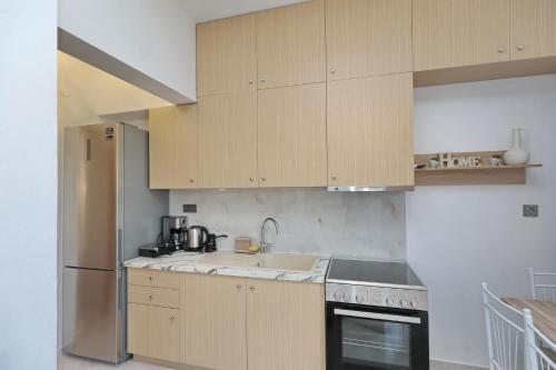 a kitchen with wooden cabinets and a sink at Smile Stella Studios in Skopelos Town