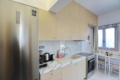 a kitchen with wooden cabinets and a stainless steel refrigerator at Smile Stella Studios in Skopelos Town