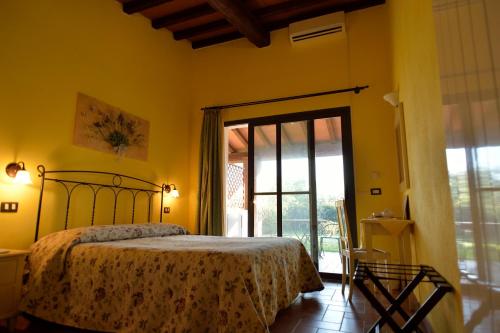 a bedroom with a bed and a sliding glass door at Il Gelsomino in Alberese