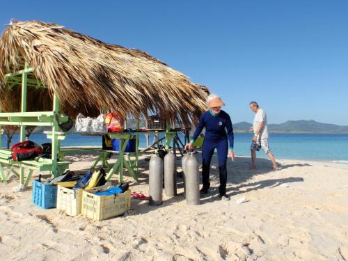 Ein paar Leute stehen am Strand in der Unterkunft Corales Punta Rusia in Punta Rucia