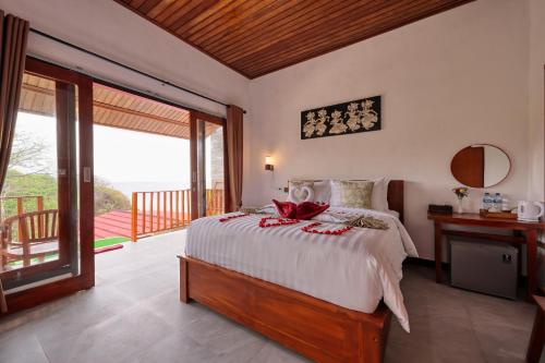 ein Schlafzimmer mit großem Bett und Balkon in der Unterkunft Kapouk Cottage in Nusa Penida