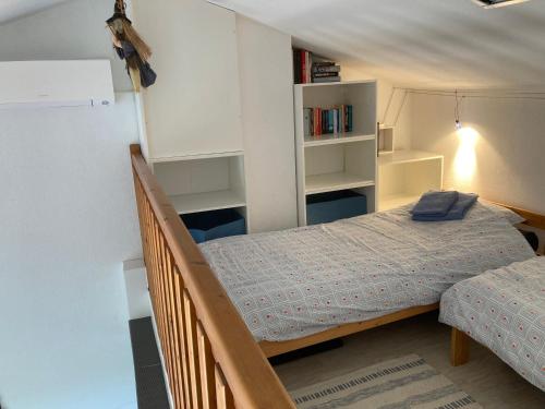 a small bedroom with a bed and a staircase at Maisons du lac in Le Barcarès