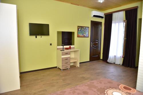 a room with a desk and a television on the wall at Sheki Panorama Guest House in Sheki