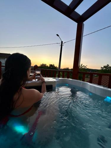 a woman taking a picture in a hot tub at Casa do Souto - Nature & Experiences - Turismo Rural in Bragança