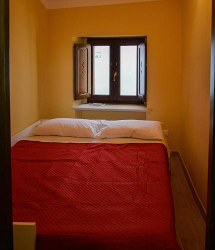 a bed in a room with a window at GarganoMareBorghi ospitalità diffusa in Vico del Gargano