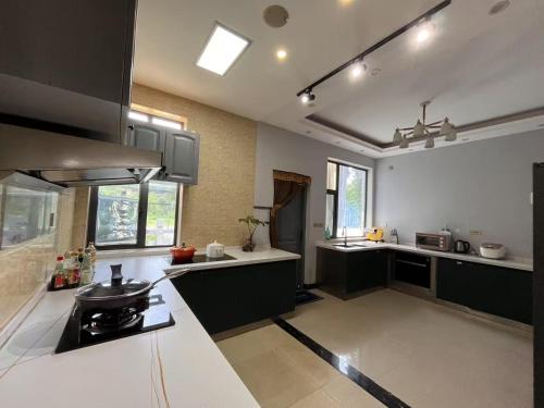 a large kitchen with black and white counter tops at Guilin Tranquil Peaks Retreat by Reed Flute Cave in Guilin