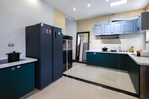 a large kitchen with blue cabinets and appliances at Guilin Tranquil Peaks Retreat by Reed Flute Cave in Guilin