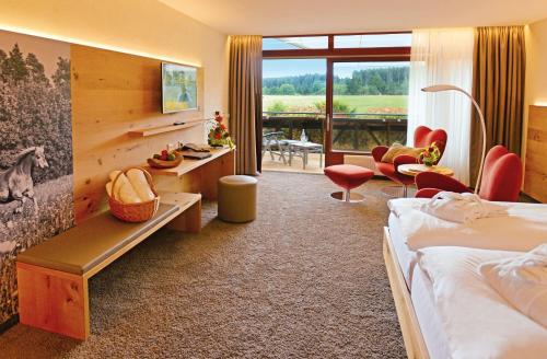 ein Hotelzimmer mit einem Bett, einem Schreibtisch und Stühlen in der Unterkunft Hotel Grüner Wald in Freudenstadt