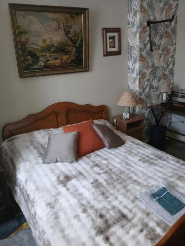 a bedroom with a large bed and a painting on the wall at Chambre " Nid Cosy " Charme et Détente chez Fred in Gorron