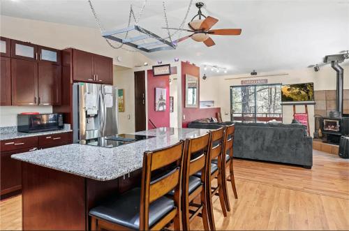 a kitchen with a counter and a bar with chairs at Eternal Treehouse Hot Tub Outdoor Oasis in Pines Entertainment Galore in Mountainaire