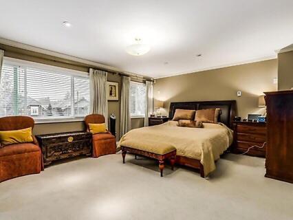 ein Schlafzimmer mit einem Bett, einem Stuhl und einem Fenster in der Unterkunft Maple Guesthouse in Vancouver