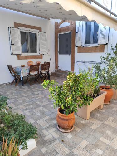 a patio with a table and chairs and potted plants at Flora's Traditional House in Malona Village