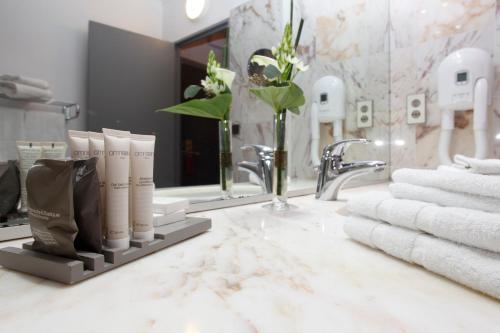 a bathroom with a sink with towels and a mirror at Alliance Lille - Couvent Des Minimes in Lille