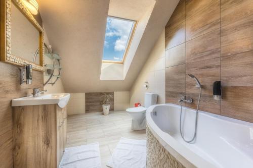 a bathroom with a large tub and a sink at Privat Gazda Pension in Ždiar